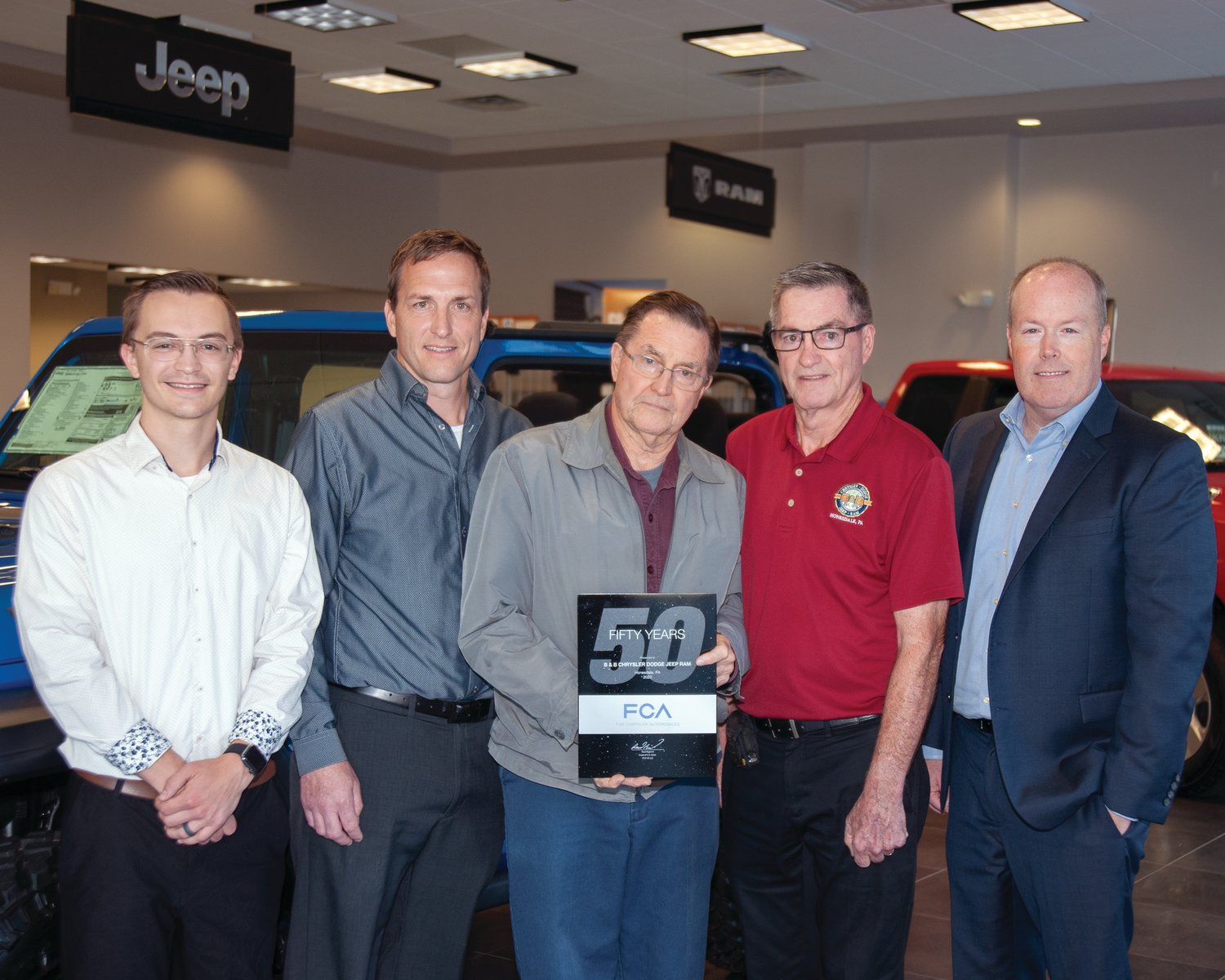 Marking 50 years since three Carmody brothers purchased  he Dodge automobile franchise in Honesdale,.Mason Carmody, left, Stephen Carmody Jr., John Carmody and Stephen Carmody Sr. welcomed John M. Mack, director of Chrysler Group’s mid-Atlantic business center to the dealership.